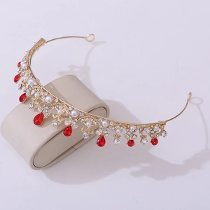 Macro shot of gold princess tiara with red crystal drops and white faux pearls