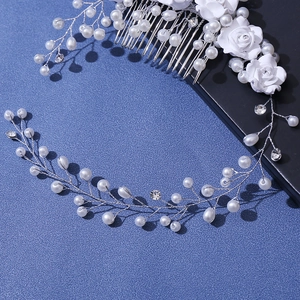 Close-up of handmade white fabric roses and pearls on a bridal hair comb and headband