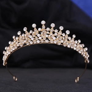 Gros plan d'une couronne dorée luxueuse avec cristaux sur velours noir