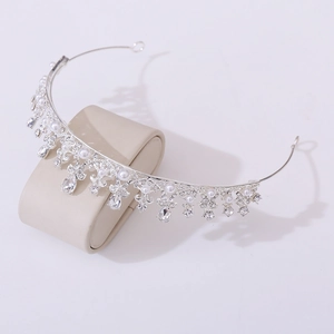 Detailed close-up of silver princess crown with white pearls and sparkling crystals