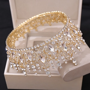 Close-up of a gold bridal crown with crystals in a beige jewelry box at a 45-degree angle
