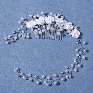 Handmade bridal hair comb with white roses, faux pearls and crystals on blue background