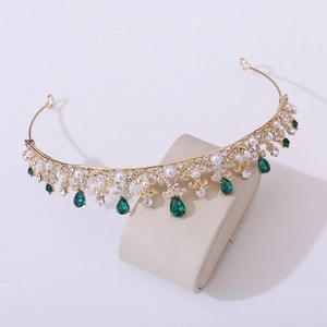 Detailed view of golden princess crown with emerald droplets and white pearls