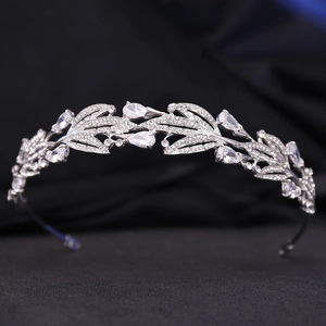 Macro view of silver bridal tiara featuring leaf motifs and pear-shaped crystals