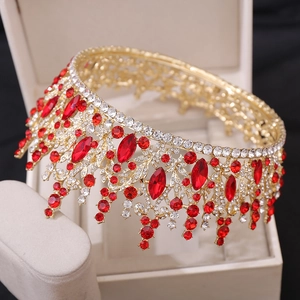 Close-up of golden bridal crown with red crystals and intricate openwork details