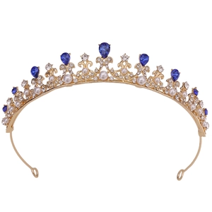 Golden crown for girls with blue teardrop gems and white pearls on white background