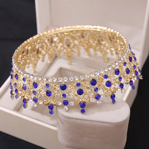 Detailed side view of golden bridal crown with blue rhinestones on jewelry display