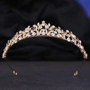 Detailed view of bridal gold crown with sparkling crystals on dark blue velvet