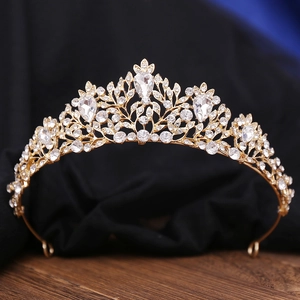 Close-up of golden bridal crown with intricate leaf patterns and teardrop rhinestones