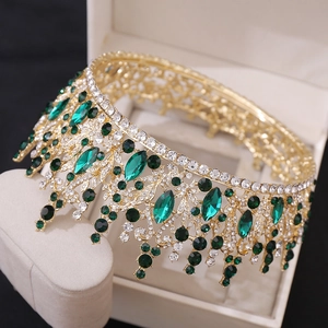 Macro detail of bridal crown with emerald and clear crystals on golden alloy base