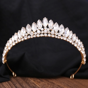 Détail d'un diadème de mariée doré avec des strass en cristal étincelants sur fond noir