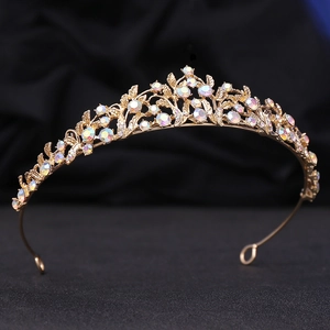 Detailed close-up of golden bridal tiara with sparkling iridescent crystals and leaf patterns