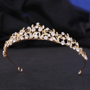 Close-up of gold bridal tiara with white rhinestones on luxury blue velvet fabric