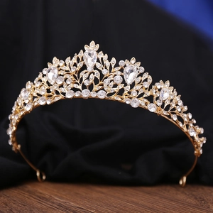 Macro detail of golden baroque bridal crown with pear-shaped rhinestones and leaf patterns