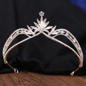 Macro shot of silver bridal crown with crystal leaf details on a wooden surface