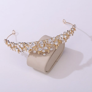 Elegant gold bridal tiara with sparkling crystal leaves on a white display stand