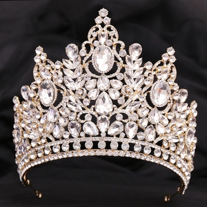 Close-up of golden bridal crown with sparkling crystal rhinestones on black fabric