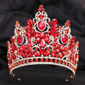 Detailed macro shot of large baroque wedding crown with red crystals and gold metal