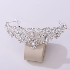 Close-up of baroque silver crown featuring floral patterns and pear-cut crystal centerpiece