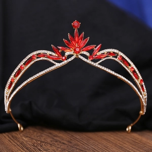 Close-up of golden bridal tiara featuring red marquise crystals and sparkling rhinestones