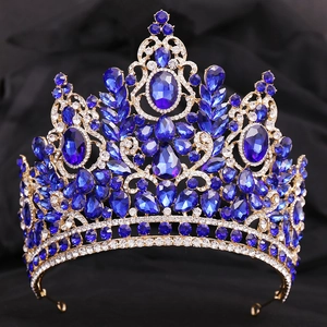 Detailed view of Baroque gold tiara with deep blue crystals on black velvet