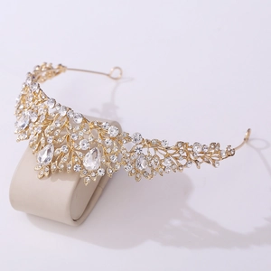 Detail of a gold baroque bridal crown with sparkling rhinestones on a display stand