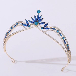 Detail of golden bridal crown featuring royal blue crystals and sparkling leaf patterns