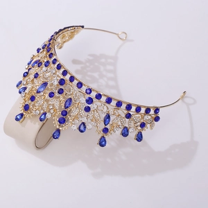 Close-up of gold bridal crown featuring dark blue teardrop crystals and floral hollow design