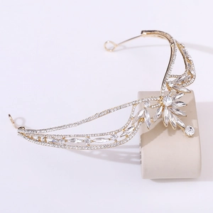 Detailed macro view of gold bridal tiara with intricate crystal leaf and wing design