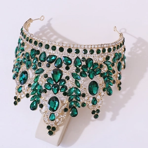 Detailed close-up of golden bridal crown with emerald green crystals and white rhinestones