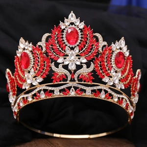 Détails de la couronne dorée aux pierres rouges ovales et motifs de feuilles sur velours noir