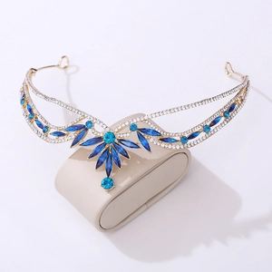 Detailed shot of golden wedding tiara with blue marquise crystals on a jewelry stand