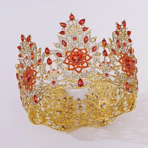 Gros plan d'une couronne baroque dorée avec pierres rouges en cœur et des strass blancs