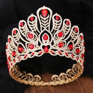 Vue détaillée d'une grande couronne dorée sertie de cristaux rouges et de strass étincelants