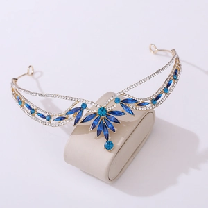 Detailed macro view of vintage gold crown featuring deep blue crystal and leaf motifs