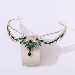 Detailed view of bridal crown with green marquise gems and gold alloy leaf vine patterns
