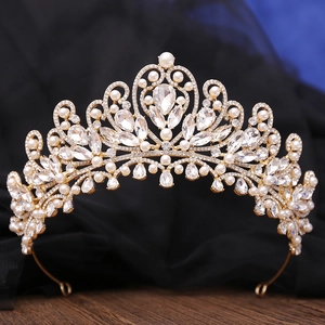 Close-up of golden baroque crown with sparkling crystals and elegant white pearls