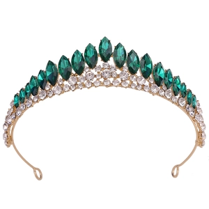 Détail d'une couronne de mariée dorée avec cristaux émeraude et strass blancs