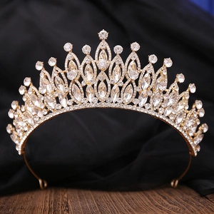 Gros plan d'une couronne de mariée dorée avec des strass étincelants sur fond sombre