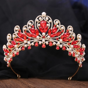 Macro detail of luxury gold bridal crown with red crystals and white pearls on black base