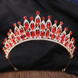 Détail d'une couronne de mariée dorée avec strass rouges sur fond de bois vintage