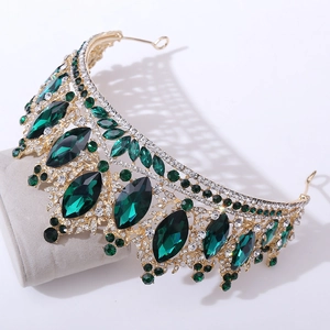 Détail de couronne baroque dorée avec strass marquises verts sur support velours