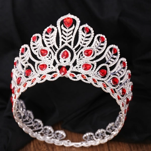 Détail d'une couronne argentée avec gemmes rouges et strass blancs sur soie noire