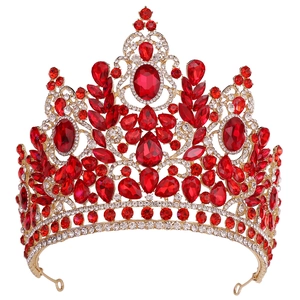 Macro shot of gold wedding crown with large red crystals and intricate rhinestone patterns