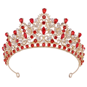 Detailed macro view of baroque gold tiara featuring red gemstones and white crystals
