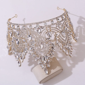 Close-up of golden baroque bridal crown with teardrop crystals on a display stand