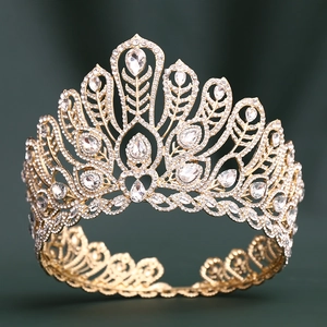 Détails d'une grande couronne dorée avec motifs de plumes et cristaux de zircon blancs