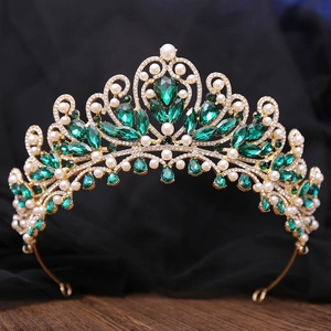 Detailed close-up of emerald green crystals and white pearls on golden crown