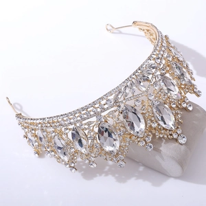 Vue latérale macro d'une couronne baroque dorée avec diamants marquise sur support gris