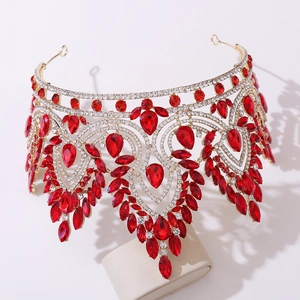 Close-up of golden Baroque crown with large red crystal teardrops and white rhinestones